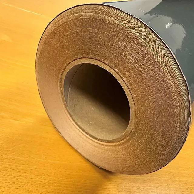 Nærbilde av enden på en rull med grå folie, der lagene i rullen er godt synlige.