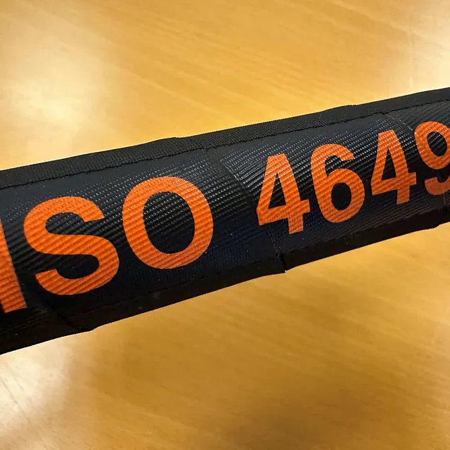 ISO 4649-merking trykket i oransje på sort, teksturert slangeoverflate.