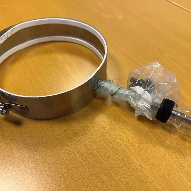 Båndvarmer med tilkoblet glassbeholder og plastbeskyttelse rundt koblingen.