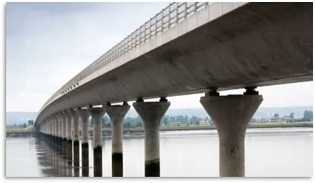 Lang, grå bru over et vann