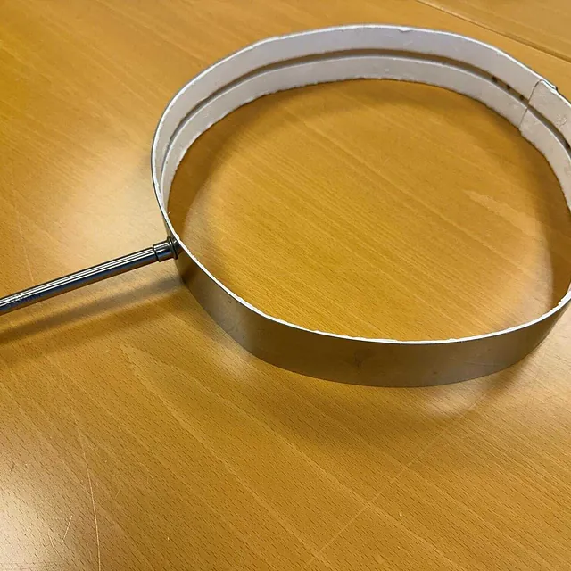 Metallbåndvarmer med hvit isolasjon og fastmontert metallstang på siden.